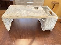 Angled view showing overall tray, raised legs, wicker weave and cup holder