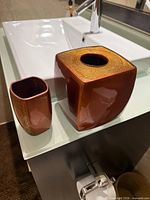 Front view of ceramic tissue box cover and tumbler on sink