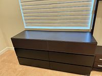 Front view of dark brown six-drawer dresser closed