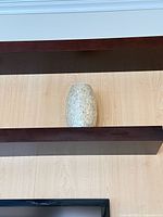 Front view of the vase on shelf showing full shape and mosaic surface