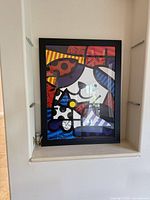 Full view of signed framed print in black frame