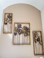 Three metal flower wall panels displayed together