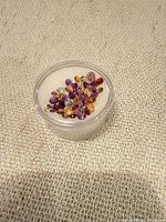 Top view of jar showing mixed loose gemstones