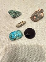Closer view showing colors of green, tan, turquoise scarab, black, and brown matrix