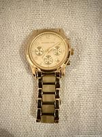 Front view of gold-tone Michael Kors chronograph watch showing dial and bracelet segment
