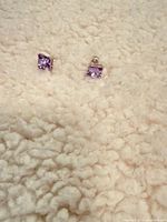 Both stud earrings on fabric background showing stone color and setting