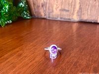 full view of ring standing upright on wood surface, shows overall design