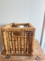 Front and right side view of square wicker basket showing cutout handle and weave pattern