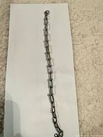 Full view of silver-tone stainless steel bracelet laid flat