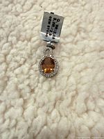 Front view of pendant showing citrine stone, halo, bail and tag