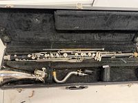 Open case showing bass clarinet body, neck, bell and mouthpiece