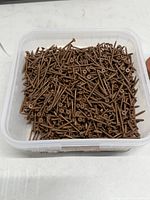 Top view showing quantity of brown deck screws inside pail