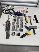 Full layout of clipper, blades, scissors and assorted tools on table