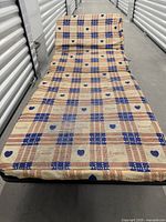 Bed unfolded with patterned mattress cover visible