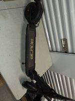 Full side view of scooter on table showing deck branding and rear wheel