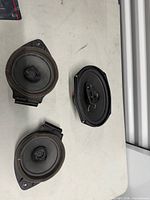 Front view of three car speakers showing cones and tweeters