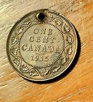 Reverse of 1915 Canada One Cent coin showing hole near rim