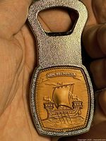 Front view showing tall ship and New Brunswick banner on bottle opener