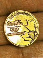 Obverse showing full design and inscriptions on coin held between fingers