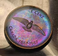 Front view of toned 1967 Canadian centennial cent in holder