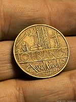 Reverse side of French 10 Franc coin, abstract industrial motif and 10 FRANCS legend