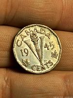 Reverse showing V torch design, date 1945, denomination