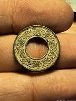 Reverse side with ornate vine design visible