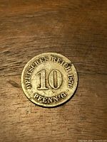 Front of 1876 10 Pfennig coin on wood surface