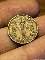 Reverse of 1943 Canadian V nickel showing torch, maple leaves and date