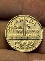 Reverse of 1951 Canada 5-cent coin showing refinery design and dates