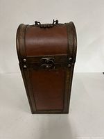 Closed wood wine bottle box showing front, latch and curved lid