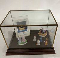 Overall view of glass display case with figurines and booklet