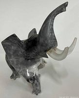 Front angle of grey marbled onyx elephant figurine showing raised trunk and body detail