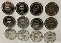 Group shot of 12 matching tokens obverse side