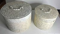 Both canisters side by side showing size difference and embossed design