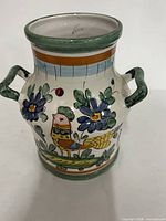 Front view showing bird and floral design, both handles, rim detail