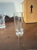 Single shot glass standing upright showing etched logo