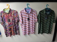 Three polo shirts on hangers showing patterns and condition