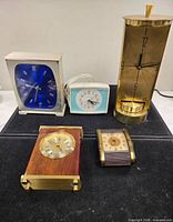 Group shot of five vintage clocks on display