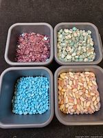 Four tubs containing the assorted beads and cabochons