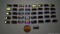Front view of 40 vitrail baguette rhinestones with penny for scale