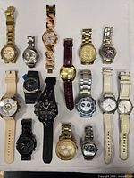 Full group of fifteen assorted wristwatches laid out in rows