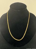 Full view of gold-filled herringbone necklace on display bust