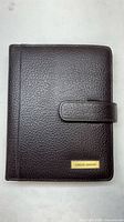 Front view of brown pebbled leather planner cover with strap closure