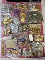 Overview of all sealed bags of findings and beads on pink surface