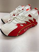 Side angle showing mesh upper, red overlays, gold accent