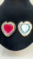 Front view of both heart-shaped purse hooks showing pink and aqua stones and rhinestones