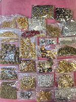 Overall lot view showing multiple bags of mixed metal findings and beads