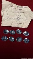 Eight oval light sapphire rhinestones and torn D.S. & Co. paper label