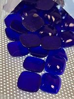 Close view of individual cobalt square pillow beads spilling from bag